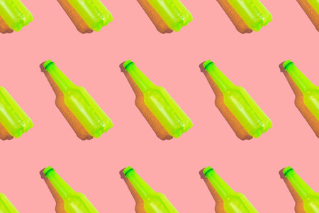 Regular pattern of acid yellow colored plastic bottles of drink on the pink backgroundの写真素材