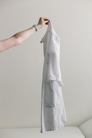 Medical gown in hand on a light background.の写真素材