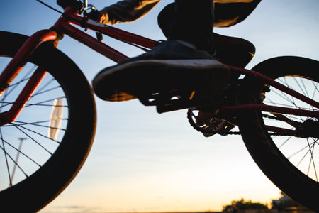 Bmx rider rides in the urban background of the sunset. Evening training at Bmx. Bmx Tricks Concept