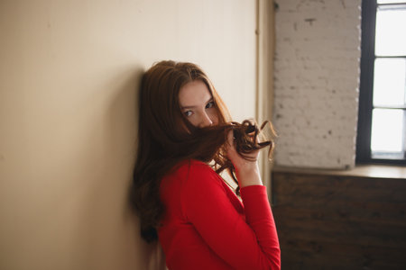 Close up young attractive woman 20s in red turtleneck isolated on plain pastel beige background studio. People lifestyle conceptの写真素材