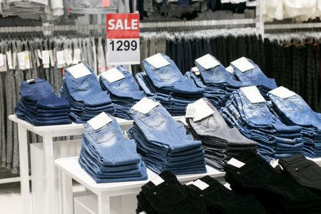 Stack of blue and black jeans in a shopの写真素材