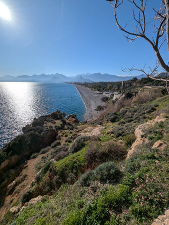 A stunningly beautiful rugged coastline adorned with sparkling waters and distant mountains beneath...