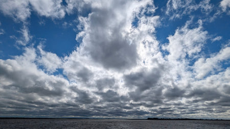 A stunning view of clouds reflecting on tranquil waters, showcasing natures exquisite and...