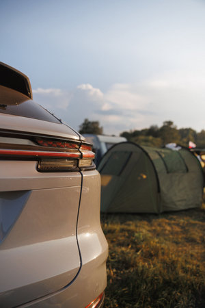 A serene camping scene featuring a car and a green tent under a beautiful sunset sky, perfect for outdoor enthusiasts and adventure seekers.の写真素材