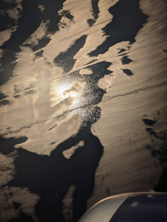 A captivating aerial view depicting sunlight reflecting beautifully on water, with textured patterns...
