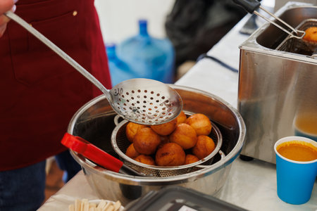 Golden, fluffy dough balls are fried to perfection, showcasing culinary artistry and delightful street foodの写真素材