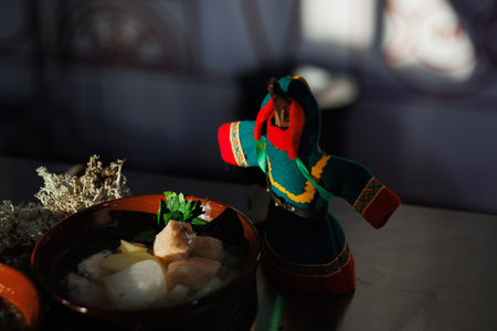 A colorful, handcrafted doll is beautifully placed next to a delicious dish, showing casing rich cultural heritageの写真素材