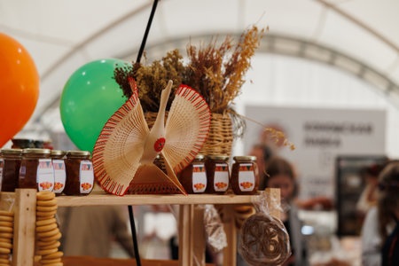 A vibrant market stand showcasing various artisanal products, decorated with flowers and cheerful balloonsの写真素材