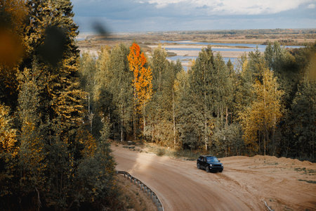 A car is cruising along a bumpy and unpaved dirt road that winds its way through the beautiful woods...