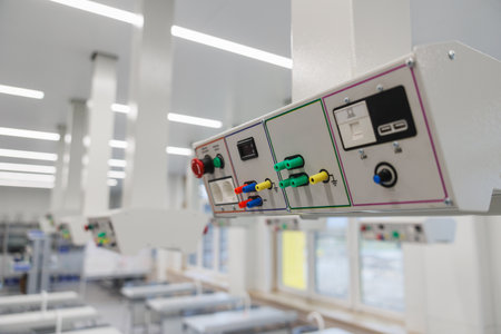 Closeup of a ceilingmounted medical gas panel in a bright modern ward, featuring oxygen outlets,...