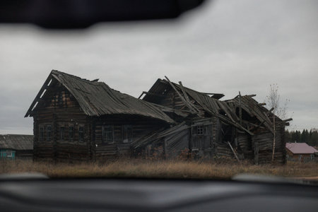 old abandoned house in ruins, neglected wooden rural home with collapsed roof and broken windowsの写真素材