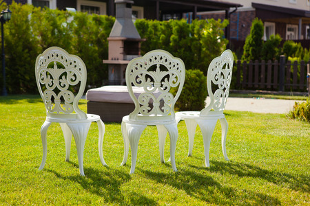 carved white chairs on the lawn in the courtyardの写真素材