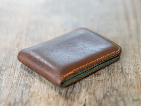 Brown leather wallet on wooden tableの写真素材