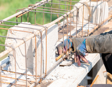 Workers are using steel wire to bind steel bars with pilers.の写真素材