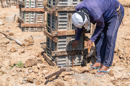 The workers drove steel rods to support the formwork for pouring the concrete column cap in construction site..の写真素材