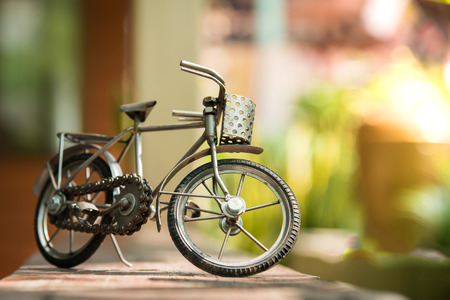 Close up of steel toy bicycle on the wood plankの写真素材