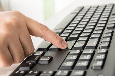 Close up finger pressing enter on keyboard