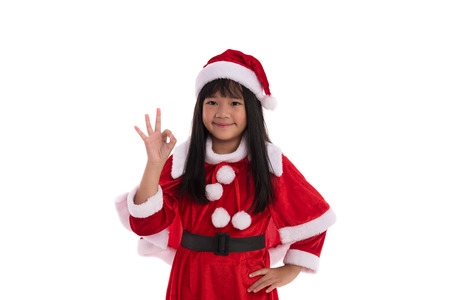 Close up of cute asian girl dress up in santa claus suite on white background isolatedの写真素材