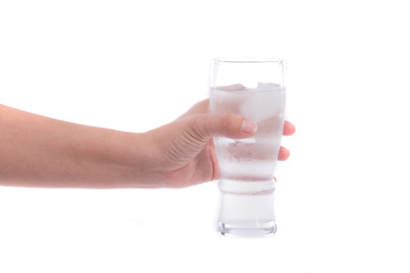 Close up of hand holding glass with cold water on white background isolated.の写真素材