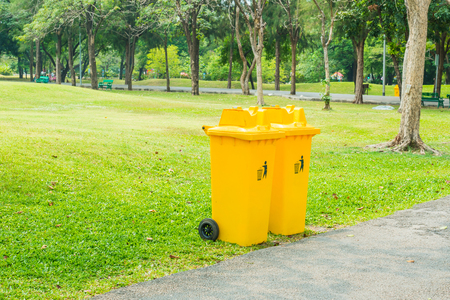 Close up of yellow plastic bin on ground in the park.の写真素材