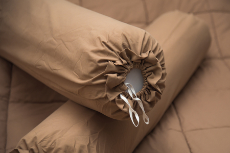 Close up of brown bolster on the brown blanket.の写真素材