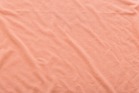 Close up of beautiful wrinkle coral color bedsheet fabric texture.の写真素材