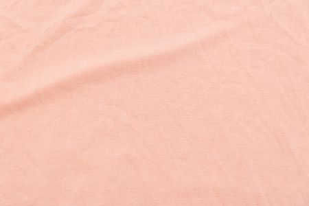 Close up of coral wrinkled bed sheet textured background.の写真素材