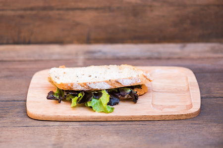 Close up of fresh organic sandwich bread fill with fresh vegetable on wooden dish.の写真素材