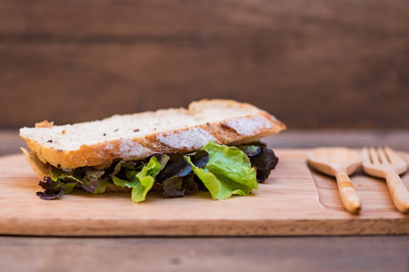 Close up of fresh organic sandwich bread fill with fresh vegetable on wooden dish.の写真素材