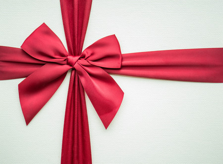 Close up of beautiful red fabric ribbon on wooden paper gift box.の写真素材