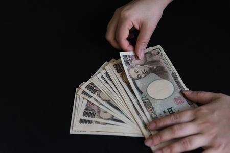 Close up of japan banknote in women hand.の写真素材