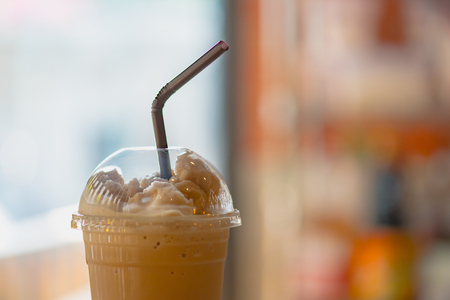 Close up of capuchino frappe in plastic cup on wooden table.の写真素材