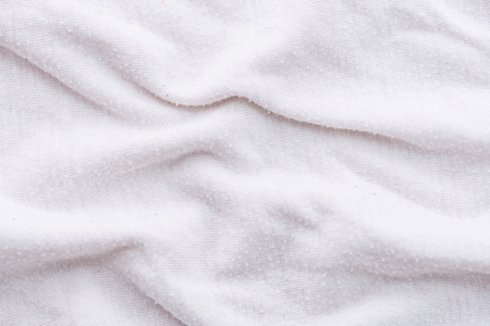 Close up of old dirty wrinkled white bedsheet fabric texture background.の写真素材