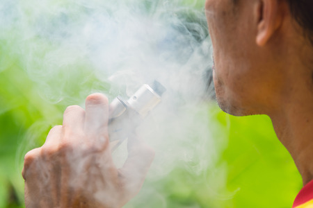 Close up hand of man hold electronic cigarette and smoking.の写真素材