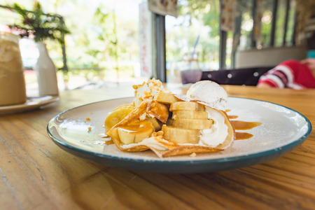 Close up of fresh baked caramel banana crepe topping with whip cream, cramel sauce and crumble.の写真素材