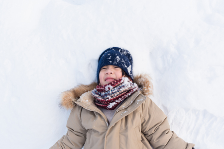 Close up of cute asiain boy play and lying on powder snow on vacation in Aomori Japan.の写真素材