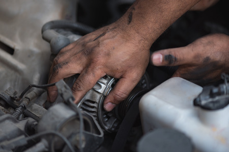 Close up dirty mechanic hand try to fix engine in maintenance service.