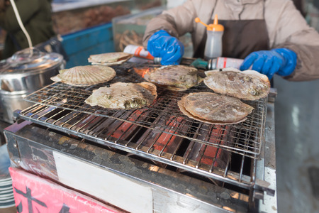 Fresh japan scallop or hotate grilled on the oven in morning market Hakodate Japan.の写真素材