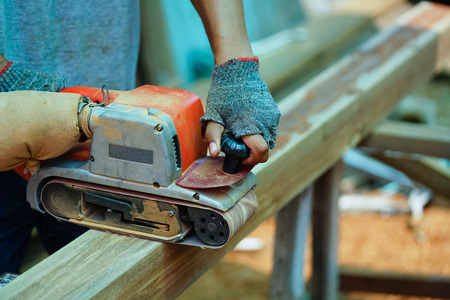 Man working on the electric wood sanding machineの写真素材