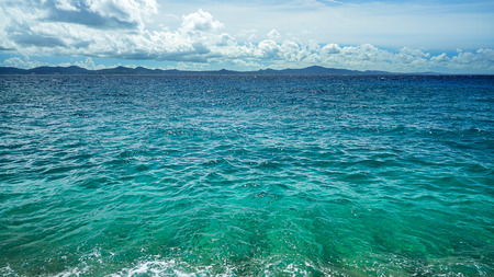 Beautifulness of the blue sea with the background of cloudy sky and island.の写真素材