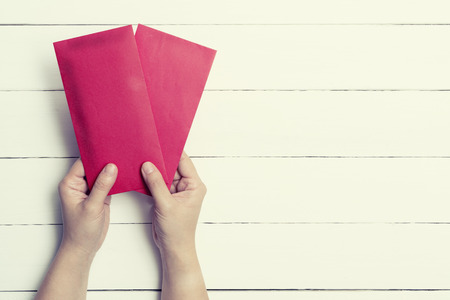 Red Envelope or red packet for Chinese New Year Gifts held in hand with pastel toned, Traditional Celebration Chinese New Year.の写真素材