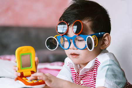 Kid wearing eye glasses playing the toy with fun.の写真素材