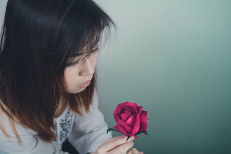 Portrait of Asian Women and Pink Rose in unhappy mood. selective focused.の写真素材