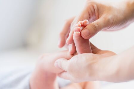 Close up scene of baby massage therapy for baby happy and reduce crying with sleep more, apply baby oil on the foot, selective focused on baby foot and shot on soft natural sunlight with copy space.の写真素材