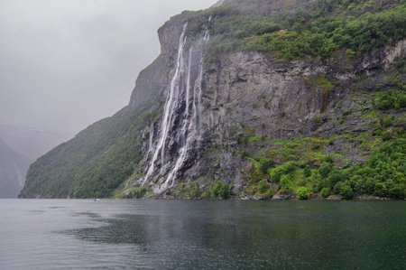 view of the seven sisters waterfall in a fiord in norway on a rainy and foggy dayの写真素材