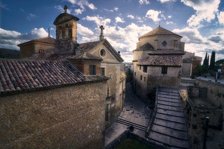 a church and old buildings on the narrow streets of Cuenca, Spain at sunsetの写真素材