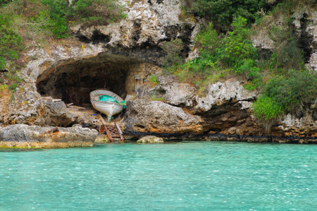 a boat in a cave on the rock next to a beach in Majorcaの写真素材