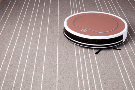 robotic vacuum cleaner on grey carpet smart cleaning technologyの写真素材