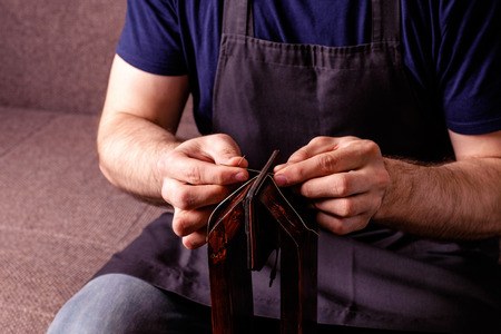 leather craft tailoring process, men's hands sewing brown wallet in Stitching Ponyの写真素材