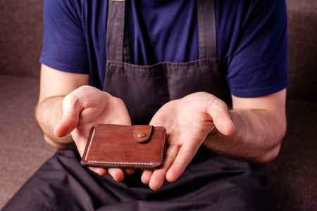 leather craft brown wallet in Tanners hands close upの写真素材